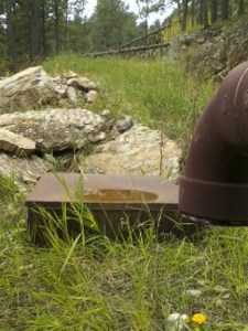 This pit is below (EAST) of our water tanks and is locked . It supplies water to the 5000 gallon underground tank north of Dr Gilbert's shop which supplies water to Dr Gilbert and both Samuelson's.